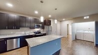This contemporary 790 square foot apartment offers a harmonious blend of style and functionality. The heart of the home is an open-concept kitchen and living area, showcasing dark wood cabinetry contrasted with stainless steel appliances and light granite countertops. A central island with a blue accent provides additional prep space and casual dining.

The spacious bedroom, measuring 210 square feet, features plush carpeting, a modern ceiling fan, and large windows that invite natural light. The bathroom continues the modern aesthetic with a dark wood vanity, granite countertop, and wood-look tile flooring. Ample storage is provided by built-in shelving.

Throughout the apartment, wood-look flooring adds warmth and durability to the living spaces. A private balcony, accessible through sliding glass doors, extends the living area outdoors, offering views of the surrounding area.

The efficient layout maximizes the use of space, with thoughtful design elements like recessed lighting and an in-unit laundry area. Located at 509 W Verona Ave in Verona, WI, this single-floor apartment combines urban convenience with contemporary comfort, making it an ideal home for modern living.