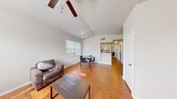 Located at Jefferson Commons in Kalamazoo, MI, this five-bedroom, two-bathroom unit is thoughtfully laid out across a single floor. The open-concept living and dining area serves as the heart of the home, featuring vaulted ceilings, warm hardwood-style flooring, a ceiling fan with integrated lighting, and track lighting that brightens the space. Large windows allow natural light to pour in, creating a welcoming atmosphere. A dining area sits adjacent to the living room, flowing seamlessly into the galley-style kitchen, which is equipped with light wood cabinetry, dark granite-style countertops, a double sink, dishwasher, refrigerator, and electric range. The five bedrooms are carpeted and comfortably sized, with the primary bedroom offering a private en-suite bathroom. Both bathrooms feature light wood vanity cabinetry, granite-style countertops, and mirrored medicine cabinets. A dedicated closet provides additional storage. The consistent hardwood-style flooring throughout the common areas ties the layout together, while the clean, neutral color palette gives the space a bright and functional character throughout.