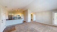 Located at 2000 Burgess Dr in Uniontown, OH, this well-appointed one-bedroom, one-bathroom unit offers a thoughtfully designed single-floor layout. The living room is a standout feature, boasting soaring vaulted ceilings that create an airy, open ambiance, complemented by plush wall-to-wall carpeting and multiple windows that flood the space with natural light. A private exterior door provides convenient access to the outdoors. The kitchen flows seamlessly from the living area and is equipped with a full suite of stainless steel appliances — including a refrigerator, electric range, built-in microwave, and dishwasher — paired with dark countertops, white cabinetry, and durable hardwood-style flooring. The bedroom features vaulted ceilings, dual windows with outdoor views, and carpeted flooring, and is complemented by a spacious walk-in closet outfitted with wire shelving and hanging rods for ample storage. The full bathroom includes a combined tub and shower, a single-sink vanity with dark countertop, and hardwood-style flooring. A dedicated in-unit laundry room houses a full-size washer and dryer, adding everyday convenience to this functional and comfortable living space.