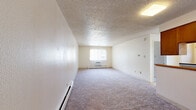 This 570 square foot, single-story apartment in Boulder, Colorado offers a practical living space with a thoughtful layout. The property features one bedroom, measuring 150 square feet, which provides ample space for a comfortable sleeping area. The bedroom is carpeted and includes a large window that allows natural light to filter in, creating a bright and airy atmosphere.

The apartment's single bathroom is efficiently designed with white tiled walls, a combined bathtub and shower, and a window for ventilation. The kitchen, while compact, is well-equipped with wooden cabinetry, providing ample storage space. It includes essential appliances such as a refrigerator and a stove with an oven. The kitchen's layout maximizes functionality in the limited space, with a window above the sink area bringing in natural light.

The main living area is an open-concept space, ideal for a combined living and dining arrangement. It features wall-to-wall carpeting and large windows that offer views of the surrounding area. The room's neutral color palette and textured ceiling create a clean, modern aesthetic. Baseboard heating units are visible, ensuring comfort during colder months.

Throughout the apartment, the walls are painted in light, neutral tones, contributing to a sense of spaciousness. The property's layout is designed for efficiency, with a hallway connecting the various rooms and providing easy access to all areas of the home.