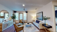 This single-floor residence offers a thoughtfully designed layout that balances comfort and contemporary style throughout. The living room serves as a welcoming central gathering space, featuring rich hardwood flooring, a ceiling fan, recessed lighting, and multiple windows dressed with navy-accented curtains that invite natural light while maintaining privacy. The room comfortably accommodates a full seating arrangement anchored by a patterned area rug.

The adjacent dining area flows naturally from the living space, highlighted by an elegant orb chandelier and hardwood flooring that continues from the main living area. The kitchen is a standout feature, showcasing dark espresso cabinetry, granite countertops, a striking geometric tile backsplash, stainless steel appliances including a gas range and French door refrigerator, and a deep farmhouse sink.

The primary bedroom is distinguished by a bold navy accent wall, plush carpet, a ceiling fan, and generous natural light. A second bedroom offers a calm, neutral palette with soft carpet and ample space. The bathroom features dark cabinetry with white countertops, tile flooring, and direct access to a walk-in closet. A dedicated laundry room with side-by-side washer and dryer, granite countertops, and dark cabinetry adds notable convenience.