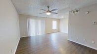 This thoughtfully designed one-bedroom, one-bathroom unit offers a comfortable and functional single-floor layout. The living room is a bright, open space featuring durable hardwood-style flooring, neutral warm-toned walls, and a ceiling fan with integrated lighting. Vertical blinds and a secondary window allow for natural light throughout the day, while the textured ceiling adds a classic touch. A solid entry door provides a defined entryway into the living area.

The kitchen is efficiently designed with gray shaker-style cabinetry, light countertops, a stainless steel sink, a dishwasher, and a white subway tile backsplash, creating a clean, modern aesthetic. Hardwood-style flooring continues seamlessly from the living area into the kitchen.

The bedroom is a comfortable, carpeted retreat featuring its own ceiling fan with lighting, a window fitted with blinds for light control, and neutral walls that provide a calm atmosphere. A dedicated closet adds practical storage.

The bathroom includes a full bathtub and shower combination with white tile surround, maintaining a clean and functional design consistent with the rest of the unit. Overall, the space presents a cohesive, move-in-ready interior with consistent finishes throughout.
