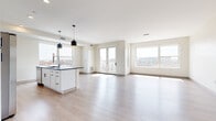 Located at 2819 Detroit Ave in Cleveland's vibrant Ohio City neighborhood, this single-floor unit offers a thoughtfully designed open-concept layout filled with abundant natural light. Large windows throughout frame urban views of the surrounding cityscape, including glimpses of Cleveland's skyline, creating a bright and airy atmosphere across the entire space.

The kitchen serves as a central feature, showcasing white shaker cabinetry with matte black hardware, dark granite countertops, a subway tile backsplash, and a full suite of stainless steel appliances including a refrigerator, range, microwave, and dishwasher. A generously sized island with an integrated sink anchors the space, while pendant lighting adds a modern accent. The kitchen flows seamlessly into the open living and dining area, which is finished with light wood-style flooring and leads to a private balcony through glass-panel doors.

The bedroom is carpeted and well-proportioned, featuring a large window with urban views and access to a spacious walk-in closet outfitted with wire shelving systems. A second walk-in closet provides additional storage. The bathroom is finished with wood-style flooring, a white vanity with dark granite countertops, a round mirror, and a shower-tub combination.