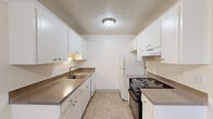 Located on SW Laurelwood Drive in Portland, Oregon, this one-bedroom, one-bathroom unit offers a practical and well-organized single-floor layout. The living room features wall-to-wall carpeting, a textured ceiling, baseboard heating, and a wall-mounted air conditioning unit. A sliding glass door opens to a private balcony, allowing natural light to flow into the space, while an additional window provides a secondary source of daylight.

The galley-style kitchen is efficiently designed with white cabinetry lining both sides, offering ample storage above and below the counters. Dark laminate countertops complement the white cabinetry, and the kitchen is equipped with a double-basin sink, dishwasher, electric range, and refrigerator. Tile flooring runs throughout the kitchen area.

The bedroom is a generously sized room with soft carpet, a window with blinds overlooking the exterior, baseboard heating, and two sliding-door closets providing substantial storage space. An additional tiled room with a window offers flexible use as a dining area or office.

The bathroom features tile flooring, a single-sink vanity with under-sink storage, and a full tub-shower combination with a stone-patterned surround. The unit's clean, neutral palette and functional design make it a comfortable and practical living space.