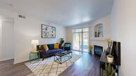 Located at 1300 S Willow St in Denver, CO, this well-appointed one-bedroom, one-bathroom residence offers a thoughtfully designed single-floor layout. The bright and welcoming living room features rich hardwood-style flooring, a classic fireplace with a white mantel, a decorative arched wall niche, and sliding glass doors that open to a private outdoor area, filling the space with natural light. The open-plan kitchen is equipped with stainless steel appliances, white cabinetry, granite countertops, a breakfast bar peninsula, and track lighting, flowing seamlessly into a dedicated dining area ideal for everyday meals. The bedroom offers a comfortable, carpeted retreat with generous proportions and a dedicated closet for ample storage. The full bathroom includes a tiled tub-and-shower combination, granite-topped vanity, and wood-style flooring. A hallway connects the main living areas to the bedroom and bathroom with ease. Completing the layout is a dedicated in-unit laundry area with a full-size washer and dryer. The clean white walls and consistent flooring throughout create a cohesive, modern aesthetic that makes this residence both practical and inviting.