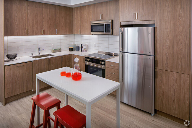 Our kitchens feature stainless steel appliances, tile backsplash and wood-grain cabinets - Pace Apartments