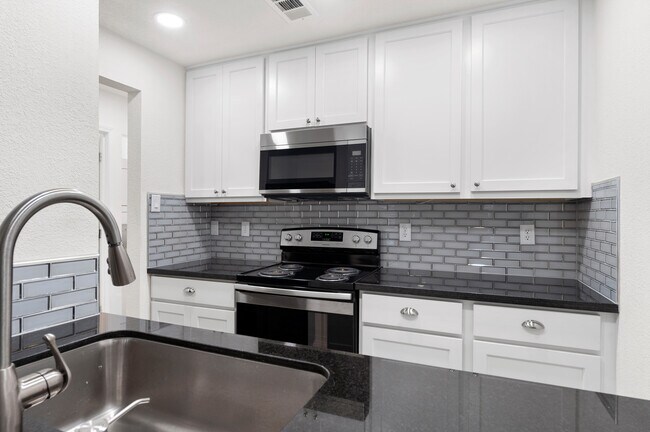 Kitchen with granite countertops, sleek backsplash and new appliances. - 1501 Stallings Dr