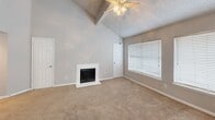 Located at 12200 Overbrook Lane in Houston, TX, this one-bedroom, one-bathroom residence offers a thoughtfully arranged single-floor layout. The living room is a standout space, featuring dramatic vaulted ceilings that create an impressive sense of height and openness. A white-surround fireplace serves as the room's focal point, complemented by soft carpeting, a ceiling fan, and multiple windows fitted with blinds that allow for natural light control. The kitchen is well-appointed with dark espresso cabinetry, granite-style countertops, black appliances including a gas range and refrigerator, a center island with matching countertop, and hardwood flooring — providing both functionality and a modern aesthetic. The bedroom is generously proportioned, offering plentiful natural light through large windows, a ceiling fan, and comfortable carpet underfoot. A dedicated closet provides practical storage. The bathroom includes a full tub-shower combination with hardwood flooring and dark cabinetry for storage. A hallway with hardwood flooring connects the key areas of the home, while the entrance provides a welcoming transition into the space. Textured ceilings are found throughout, adding a consistent architectural detail across the home.