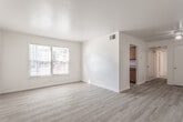 Located at 106 Williamsburg Dr in Chesapeake, VA, this single-story unit offers a straightforward, functional layout designed for comfortable everyday living. The floor plan connects a spacious living area to the rest of the home via a central hallway, creating a logical flow throughout the space.

The living area is generously proportioned, featuring light-toned luxury vinyl plank flooring that extends through the main common areas. A large multi-pane window allows natural light to fill the room, contributing to an open and airy atmosphere. A ceiling fan adds practical comfort, and the neutral white walls provide a clean, versatile backdrop.

The kitchen is efficiently arranged with warm-toned wood cabinetry lining both sides, granite-style countertops, a black electric range, and a wall-mounted exhaust fan. A window above the counter area brings in additional natural light.

The hallway, also finished with LVP flooring, connects the main living spaces to the bedrooms and includes a louvered closet door, offering convenient storage. The bedrooms are carpeted in a neutral beige tone, with multiple windows providing cross-ventilation and natural light. Each room offers a comfortable amount of space suitable for standard furnishings.

The bathroom is clean and functional, featuring a full soaking tub and shower combination with white surrounds and chrome fixtures, paired with LVP flooring for easy maintenance.