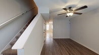 Located at 1825 Madison St in Clarksville, Tennessee, this two-story home offers a thoughtfully laid-out interior with distinct flooring and finishes across its levels. The main floor features rich, dark hardwood-style flooring that runs throughout the living areas, complemented by neutral gray walls and white trim. A staircase with a white-painted banister connects the floors, and ceiling fans with integrated lighting fixtures are present throughout the home, contributing to both comfort and functionality.

The kitchen is well-appointed with dark espresso-toned cabinetry, granite-look countertops, and a full suite of stainless steel appliances, including a refrigerator with ice and water dispenser, electric range, built-in microwave, and dishwasher. Light tile flooring and under-cabinet lighting enhance the kitchen's practical appeal.

Upstairs, the bedrooms are finished with wall-to-wall carpet and ceiling fans, offering a comfortable, quieter retreat. The bathroom features light tile flooring, a tub-shower combination, a dark-vanity with white countertop, and oil-rubbed bronze fixtures and hardware, providing a cohesive, modern aesthetic. The overall palette of soft grays and warm neutrals gives the home a clean, move-in-ready appearance.