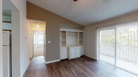 This single-story, two-bedroom, one-bathroom residence in Flowood, Mississippi offers a well-organized layout with a variety of functional and architectural details. The living area serves as the central gathering space, highlighted by vaulted ceilings that lend an open, airy feel. A standout built-in wall unit with white cabinetry and open shelving provides ample storage and display space, while rich hardwood-style flooring runs throughout. A sliding glass door fitted with vertical blinds fills the room with natural light and offers views of the outdoors.

The kitchen is equipped with white cabinetry accented by wood trim, a double-basin stainless steel sink, and generous counter space. A dedicated laundry area is accessible directly from the kitchen.

Both bedrooms are carpeted for comfort and include ceiling fans with light fixtures. Each room features windows with blinds that allow natural light to filter in, creating a bright and welcoming atmosphere.

The bathroom features hardwood-style flooring, a full tub-shower combination, a toilet, and a wide vanity with an extended countertop, single sink, and ample cabinet storage beneath, complemented by a large mirror above.
