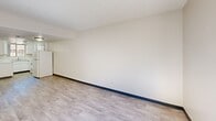 This two-story residence in Phoenix, Arizona offers a practical and well-organized floor plan across two levels. The main floor hosts the combined kitchen and living area, which features light wood-style laminate flooring and a clean, neutral color palette throughout. The kitchen is outfitted with white cabinetry, white countertops, a double-basin sink, and white appliances including an electric range, offering ample storage and workspace. The living area is open and bright with a textured ceiling and light-toned walls.

The upper level accommodates both bedrooms, each carpeted and finished with neutral walls and standard windows that bring in natural light. The primary bedroom includes a sliding-door closet for convenient storage, while the second bedroom is comparably sized and equally functional. A hallway connects the upper-level rooms.

The four bathrooms are clean and simply appointed. Bathrooms feature either a tub-shower combo or a standalone walk-in shower, each with white fixtures. Vanities include single-basin sinks with mirrors and overhead lighting. Flooring in the bathrooms transitions to light wood-style vinyl. Dark baseboards throughout the home provide a subtle contrast to the light walls and flooring, contributing to a cohesive, understated aesthetic suited for everyday living.