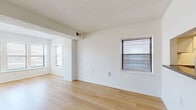 Located at 3235 Harrison St in Kansas City, MO, this 2-bedroom, 1-bathroom unit offers a clean, functional layout with consistent light hardwood flooring throughout. The open living and dining area is bathed in natural light from multiple windows fitted with blinds, and a textured ceiling adds subtle architectural character. A structural beam detail defines the transition between spaces, giving the interior a sense of purposeful design. The living area flows into a dedicated dining space, ideal for everyday use. The kitchen is efficiently arranged in a galley style, featuring white cabinetry, dark countertops, a stainless steel refrigerator, dishwasher, and range, along with a window that brings in additional natural light. Both bedrooms are well-sized, with the primary bedroom offering generous proportions and good natural light. The second bedroom includes a sliding-door closet, and the unit is notably equipped with five closets in total, providing ample storage throughout. The bathroom features a full soaking tub and shower combination with chrome fixtures. A dedicated utility room and hallway complete the layout, contributing to the unit's practical and organized flow. The overall aesthetic is bright, neutral, and move-in ready.