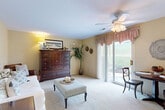 This single-floor, 2-bedroom, 1-bathroom residence offers a practical and comfortable layout across a thoughtfully organized floor plan. The combined living, dining, and kitchen area forms the heart of the home, bathed in natural light from large sliding glass doors that open to an outdoor patio with views of landscaped greenery. A ceiling fan overhead and plush wall-to-wall carpeting contribute to the warm, inviting atmosphere of the living space.

The kitchen is equipped with warm oak cabinetry, ample counter space, and a stainless steel sink, providing efficient functionality. Adjacent dining space allows for easy everyday living and entertaining.

The primary bedroom is generously sized, featuring carpet flooring, a ceiling fan, and natural light from a window. It is accompanied by a spacious walk-in closet with wire shelving, offering abundant storage. A second bedroom provides additional flexibility. The full bathroom is clean and functional, featuring a white vanity with a large mirror, tile flooring, and a shower-tub combination.

Additional highlights include a dedicated laundry room with a full-size washer and dryer, a utility room, a hallway connecting the main spaces, and a total of four closets throughout, ensuring ample storage across the entire residence.