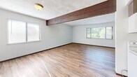 Located at 219 Freedom Dr in Belleville, IL, this single-floor, 2-bedroom, 1-bathroom residence offers a well-organized layout designed for comfortable everyday living. Wood-look plank flooring flows consistently throughout the home, lending a warm and cohesive aesthetic to every room.

The spacious living room is a standout feature, highlighted by an exposed wood ceiling beam and multiple windows that usher in generous natural light and outdoor views of the surrounding greenery. The open sightlines create a relaxed, airy atmosphere.

The kitchen is efficiently designed, featuring dark espresso cabinetry, granite-style countertops, a stainless steel sink, and white GE appliances including a range, over-the-range microwave, and refrigerator. A louvered door provides access to additional storage or utility space.

Both bedrooms are well-proportioned with neutral white walls, wood-look flooring, and natural light from well-placed windows. The primary bedroom includes a set of dark-toned sliding closet doors offering ample storage. The second bedroom also features a sliding closet. A hallway connects the bedrooms to the full bathroom, which is outfitted with a clean, white tub-shower combo and standard fixtures. The layout is completed by a connecting hallway that keeps the flow of the home efficient and practical.