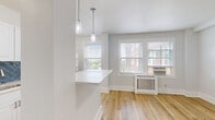 Located in Philadelphia, PA, this thoughtfully designed studio offers a well-appointed single-floor layout that maximizes every square foot. Light hardwood flooring flows throughout the main living area, complementing the bright, neutral palette of white walls and clean white trim.

The kitchen is a standout feature, boasting white shaker cabinetry, stainless steel appliances including a gas range, microwave, dishwasher, and refrigerator, as well as a striking deep blue herringbone tile backsplash that adds a bold design accent. A peninsula with a white quartz countertop provides additional prep space and doubles as a casual dining area, illuminated overhead by elegant pendant lighting.

The living area benefits from multiple windows dressed with blinds, allowing ample natural light to fill the space. A traditional white radiator cover adds a charming architectural detail beneath the windows.

The bathroom is tastefully finished with large-format slate gray floor tiles and a full bathtub and shower combination, featuring the same eye-catching blue herringbone tile extending floor to ceiling on the shower wall. A white vanity with brushed nickel hardware completes the refined look.

Additional highlights include a spacious walk-in closet with a full-length hanging rod and in-unit laundry, offering practical convenience for everyday living.