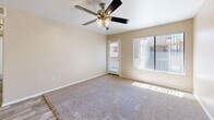 Located at 350 N Harrison Rd in Tucson, Arizona, this single-story, 3-bedroom, 2-bathroom home offers a practical and well-organized layout. The living room is bright and welcoming, featuring plush carpeting, a ceiling fan with integrated lighting, and a large picture window alongside a private exterior door that floods the space with natural light and provides outdoor access. Adjacent to the living area, the kitchen is efficiently designed with white cabinetry accented by wood-tone trim, a full suite of white appliances including a range, built-in microwave, dishwasher, and refrigerator, as well as a peninsula counter that offers additional prep space. Wood-look flooring ties the kitchen together cleanly. The three bedrooms are carpeted and bathed in natural light through vertical-blind-covered windows, offering comfortable and quiet retreats. The primary bedroom provides a generous sense of space. Both bathrooms feature wood-look tile flooring and full tub-shower combinations with white tile surrounds, presenting a clean and functional design. A hallway connects the bedrooms and bathrooms, with a dedicated closet providing additional storage. Throughout the home, neutral warm-beige tones on the walls create a cohesive and inviting atmosphere.