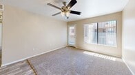 Located at 350 N Harrison Rd in Tucson, Arizona, this single-story, 3-bedroom, 2-bathroom home offers a practical and well-organized layout. The living room is bright and welcoming, featuring plush carpeting, a ceiling fan with integrated lighting, and a large picture window alongside a private exterior door that floods the space with natural light and provides outdoor access. Adjacent to the living area, the kitchen is efficiently designed with white cabinetry accented by wood-tone trim, a full suite of white appliances including a range, built-in microwave, dishwasher, and refrigerator, as well as a peninsula counter that offers additional prep space. Wood-look flooring ties the kitchen together cleanly. The three bedrooms are carpeted and bathed in natural light through vertical-blind-covered windows, offering comfortable and quiet retreats. The primary bedroom provides a generous sense of space. Both bathrooms feature wood-look tile flooring and full tub-shower combinations with white tile surrounds, presenting a clean and functional design. A hallway connects the bedrooms and bathrooms, with a dedicated closet providing additional storage. Throughout the home, neutral warm-beige tones on the walls create a cohesive and inviting atmosphere.