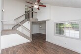 Located in the desirable 30327 zip code of Atlanta, Georgia, this two-floor residence on Noble Creek Drive NW offers a well-structured layout across both levels. The entry foyer welcomes visitors with rich, dark hardwood-style flooring and large windows that allow natural light to fill the space. The kitchen is thoughtfully designed with white cabinetry, granite countertops, a white subway tile backsplash, a double sink, and black appliances including a gas range and refrigerator. The adjacent dining area continues the hardwood-style flooring and features a pendant light fixture and vertical blind-covered sliding door access. Upstairs, the bedrooms are carpeted and feature vaulted ceilings with ceiling fans, offering an open and airy feel. The primary bedroom is notably spacious with multiple closets providing ample storage. Additional bedrooms are well-sized with neutral tones and natural light from windows. The bathrooms are finished with granite-topped vanities, white cabinetry, hardwood-style flooring, and full tub-shower combinations with white tile surrounds. Throughout, the home maintains a clean, neutral palette that is both functional and welcoming.