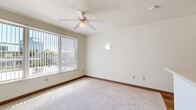 This efficient single-floor unit offers a thoughtfully organized layout that maximizes every square foot. The open living area features soft wall-to-wall carpeting, neutral cream-toned walls, and a ceiling fan that enhances air circulation and comfort. A large window dressed with vertical blinds fills the room with generous natural light and provides outdoor views, creating a bright and welcoming atmosphere.

The kitchen is efficiently designed with light wood cabinetry both above and below the countertops, offering plentiful storage. White appliances — including a range, refrigerator, and dishwasher — are included, complemented by a stainless steel sink and durable wood-look flooring that extends throughout the kitchen and entryway areas.

A hallway connects the living space to the bathroom and closet storage. The closet features wire shelving across multiple levels, providing organized and accessible storage. The bathroom is clean and functional, with wood-look tile flooring, white walls, and a grab bar for added accessibility.

Overall, the unit maintains a clean, neutral aesthetic throughout, with consistent light tones and practical finishes that create a cohesive and move-in-ready living environment.
