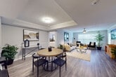 This single-floor residence offers a thoughtfully designed open-concept layout that seamlessly connects its key living spaces. The kitchen is a standout feature, equipped with stainless steel appliances including a range, dishwasher, and refrigerator, complemented by gray shaker-style cabinetry, marble-look countertops, a subway tile backsplash, and a dedicated range hood. Light wood-style flooring runs throughout the main areas, adding warmth and continuity.

The dining area sits adjacent to the kitchen and features a tray ceiling with crown molding, creating an elegant sense of definition. A pass-through counter connects the kitchen to the dining space, enhancing the open feel. The living room is bright and welcoming, with large windows that invite natural light and a ceiling fan overhead.

The bedrooms are carpeted for comfort, each with ceiling fans and windows fitted with blinds. One bedroom offers flexible use as a home office or guest room. The bathroom is well-appointed with a marble-look vanity, gray cabinetry, wood-style flooring, and a full tub-shower combination with a window for natural light.

Completing the home is a dedicated laundry area with a full-size side-by-side washer and dryer and overhead shelving for added storage convenience.