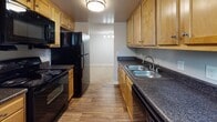 Located at 6701 Carnation St in Richmond, VA, this single-floor apartment offers a well-organized layout designed for comfortable everyday living. The galley-style kitchen is equipped with light wood cabinetry, dark granite-style countertops, a double stainless steel sink, and black appliances including a refrigerator, range, microwave, and dishwasher, all set atop durable wood-look flooring. The living area features plush carpeting and a sliding glass door framed by vertical blinds that opens to a private balcony, allowing natural light and outdoor views of surrounding greenery to fill the space. The bedrooms are generously sized with wall-to-wall carpet and neutral-toned walls. The primary bedroom includes an en-suite bathroom, while additional bedrooms feature windows with blinds that offer natural light and views of the surrounding landscape. The bathroom is outfitted with a full-size soaking tub and shower combination with clean white surround. Throughout the unit, consistent neutral wall colors, white baseboards, and ceiling-mounted ventilation create a cohesive and clean aesthetic. The overall ambiance is bright, functional, and move-in ready.