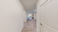 This single-story unit in Commerce, Georgia offers a practical and modern layout across three bedrooms and two full bathrooms. Light-toned, wood-look flooring runs consistently throughout the space, lending a cohesive and clean aesthetic to every room.

A central hallway connects the living areas to the bedrooms, with three closets providing ample storage. The kitchen serves as a focal point of the home, featuring rich, dark wood cabinetry, granite countertops, stainless steel appliances including a refrigerator, range, and microwave, and a peninsula island with pendant lighting above. The open design allows the kitchen to flow naturally into the main living area.

The bedrooms are well-proportioned, each equipped with ceiling fans and natural light from windows with blinds. The primary bedroom is notably spacious, offering a ceiling fan and access to a walk-in closet outfitted with wire shelving and hanging rods. The bathrooms feature granite-topped vanities with dark wood cabinetry and a shower-tub combination. One bedroom includes French doors that open to an outdoor view, adding a welcoming connection to the exterior.