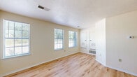 Located at 3200 Chestnut Ridge Drive in Pittsburgh, PA, this one-bedroom, one-bathroom unit offers a well-designed, single-floor layout that makes efficient use of its space. The living room is bright and welcoming, featuring light-toned hardwood-style flooring, neutral cream-colored walls, and multiple windows that invite natural light and provide views of surrounding greenery. A pass-through window connects the living area to the kitchen, enhancing the open feel between the two spaces. The kitchen is well-appointed with white shaker-style cabinetry, granite-look countertops, a stainless steel refrigerator, dishwasher, and range, all set over matching hardwood-style flooring. The bedroom offers a comfortable retreat with plush carpeting, a ceiling fan with light fixture, a window overlooking the outdoors, and access to a closet. A second closet provides additional storage. The unit also includes a dedicated laundry area, adding everyday convenience. Throughout the space, clean white trim, textured ceilings, and a consistent neutral palette create a fresh, move-in-ready atmosphere. The practical layout and updated finishes make this unit a functional and inviting home in Pittsburgh.