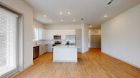 Located at 7311 Baymeadows Way in Jacksonville, FL, this single-story home offers four bedrooms and two bathrooms across a well-designed floor plan. The open-concept living, dining, and kitchen area serves as the heart of the home, featuring light wood-style flooring, recessed lighting, and a seamless flow between spaces. The kitchen is outfitted with white cabinetry, a subway tile backsplash, granite countertops, a center island, and a full suite of stainless steel appliances including a dishwasher, range, microwave, and French door refrigerator. The bedrooms are bright and airy, each equipped with ceiling fans and large windows fitted with blinds that invite natural light and outdoor views of the surrounding greenery. The primary bedroom includes access to a spacious walk-in closet with wire shelving systems for ample storage. The bathrooms are finished with granite-topped vanities, framed mirrors, and tiled tub-shower combinations. Wood-style flooring carries consistently throughout the home, creating a clean, cohesive aesthetic. A dedicated laundry area and hallway add practical functionality. The exterior features attractive brick accent columns and well-maintained landscaping.
