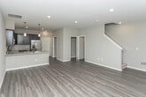 Located at 8501 26 Mile Rd in Washington, Michigan, this two-story residence offers a thoughtfully designed layout with contemporary finishes throughout. The main level features an open-concept kitchen and dining area with dark espresso cabinetry, light granite countertops, stainless steel appliances, and a peninsula with pendant lighting overhead. Wood-look luxury vinyl plank flooring extends through the main living areas, complementing the neutral gray walls and white trim for a clean, modern aesthetic. A half bathroom on the main level provides added convenience, finished with wood-look flooring and modern fixtures.

The upper level accommodates generously sized bedrooms carpeted in neutral tones, each offering windows that bring in natural light. A full bathroom serves the upper floor, featuring tile flooring, a walk-in shower with chrome-framed glass door, and a dark wood medicine cabinet. A dedicated in-unit laundry space houses a full-size washer and dryer with overhead wire shelving for additional storage.

The attached garage is spacious enough for multiple vehicles, featuring a concrete floor and an automatic opener. The 3D floor plan reveals a well-organized layout that maximizes functionality across both floors.