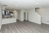 Located at 8501 26 Mile Rd in Washington, Michigan, this two-story residence offers a thoughtfully designed layout with contemporary finishes throughout. The main level features an open-concept kitchen and dining area with dark espresso cabinetry, light granite countertops, stainless steel appliances, and a peninsula with pendant lighting overhead. Wood-look luxury vinyl plank flooring extends through the main living areas, complementing the neutral gray walls and white trim for a clean, modern aesthetic. A half bathroom on the main level provides added convenience, finished with wood-look flooring and modern fixtures.

The upper level accommodates generously sized bedrooms carpeted in neutral tones, each offering windows that bring in natural light. A full bathroom serves the upper floor, featuring tile flooring, a walk-in shower with chrome-framed glass door, and a dark wood medicine cabinet. A dedicated in-unit laundry space houses a full-size washer and dryer with overhead wire shelving for additional storage.

The attached garage is spacious enough for multiple vehicles, featuring a concrete floor and an automatic opener. The 3D floor plan reveals a well-organized layout that maximizes functionality across both floors.