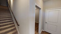 Located on S Wren Dr in Gilbert, AZ, this two-story home offers a well-designed layout spread across two levels connected by a carpeted staircase with a wood handrail. The main level features a contemporary kitchen equipped with dark espresso cabinetry, a striking granite-topped center island with an undermount sink, stainless steel appliances including a refrigerator, range, and microwave, and a crisp subway tile backsplash. Recessed lighting illuminates the space, which transitions seamlessly to wood-look plank flooring throughout the lower level. The bathrooms echo the kitchen's design with matching dark cabinetry, granite countertops, and wood-look flooring. One bathroom includes a dual-sink vanity with a large mirror and access to a walk-in closet with built-in shelving. The upper level features multiple carpeted bedrooms, each painted in soft neutral tones and fitted with ceiling fans. Several rooms include windows with blinds, allowing for natural light while maintaining privacy. A dedicated upper-floor hallway provides access to the various rooms, with additional closet storage nearby. Throughout the home, clean lines, neutral color palettes, and consistent finishes create a cohesive and functional living environment.