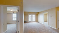 Located at 1320 Southwestern Blvd in Buffalo, NY, this single-floor unit offers a well-organized layout designed for comfortable everyday living. The open-concept living and dining area is a standout feature, characterized by warm beige carpeting, neutral-toned walls, and a set of classic French doors that invite natural light and provide access to the outdoors. A chandelier overhead adds a refined touch to the dining space, which flows seamlessly into the kitchen. The kitchen is equipped with rich medium-toned wood cabinetry, light countertops, a kitchen island with a breakfast bar overhang, and white appliances including a refrigerator, electric range, and over-the-range microwave. Tile flooring completes the kitchen area. Two carpeted bedrooms are found off the main living space, each featuring neutral walls, blinds-covered windows that allow for natural light, and multiple electrical outlets. The full bathroom is cleanly finished with tile flooring, a wood-toned vanity with a mirror and medicine cabinet, a walk-in glass-door shower, and white fixtures throughout. The overall ambiance of the unit is bright, clean, and functional, making it a practical and welcoming space.