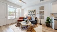 Located in Austin, TX, this thoughtfully designed one-bedroom, one-bathroom unit offers a comfortable and modern living experience across a single floor. The open-concept layout seamlessly connects the kitchen and living room, maximizing the efficient use of space. The kitchen is a standout feature, boasting white shaker cabinetry, granite countertops, a subway tile backsplash, stainless steel appliances—including a full-size refrigerator, range, microwave, and dishwasher—and a center island that provides additional prep and dining space. Wood-look plank flooring runs throughout, adding warmth and continuity. The living area is bright and inviting, enhanced by a ceiling fan and a window that brings in natural light. A hallway leads to the generously sized primary bedroom, which features windows on two walls, a ceiling fan, and ample closet space. The bathroom is clean and contemporary, with granite countertops, white cabinetry, wood-look tile flooring, and a glass-enclosed walk-in shower with marble-style tile surround. The exterior includes a concrete patio area with green lawn space, set against the backdrop of Austin's landscape.
