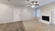 This single-floor, 2-bedroom, 2-bathroom residence offers a practical and well-appointed layout designed for comfortable everyday living. The combined kitchen and living area serves as the heart of the home, where wood-look flooring transitions seamlessly into carpeted living space. The kitchen features dark espresso cabinetry, granite-look countertops with a breakfast bar overhang, mosaic tile backsplash, and white appliances including a refrigerator, range, and over-the-range microwave. The living room is bright and inviting, highlighted by a classic white brick fireplace, a ceiling fan with light kit, and windows with blinds that allow ample natural light. Both bedrooms are carpeted and equipped with ceiling fans, offering a comfortable and quiet retreat. Each bedroom includes its own dedicated closet, one of which is a walk-in closet with built-in shelving for generous storage. The two bathrooms are finished with dark wood-tone cabinetry, tile backsplash accents, and tub-shower combinations with white tile surrounds. Wood-look flooring runs through the bathrooms and hallways, tying the design together cohesively throughout the home.