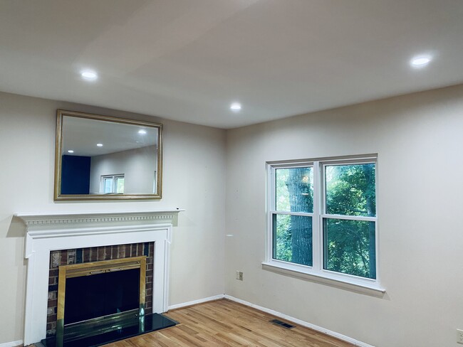 Light-filled living room with recessed lighting, fireplace and accent wall - 1777 Redgate Farms Ct