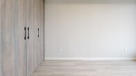 Located at 20 George St in the heart of Hamilton, Ontario, this modern 2-bedroom, 2-bathroom unit offers a thoughtfully designed layout with contemporary finishes throughout. Light wood-look flooring flows seamlessly across the entire space, complementing the neutral warm-grey palette that creates a clean, cohesive aesthetic.

The living room is bright and open, featuring floor-to-ceiling windows and direct access to a private balcony, offering sweeping elevated views of the Hamilton cityscape and surrounding landscape. The tray ceiling detail in the living area adds architectural interest and a sense of depth.

Both bedrooms are generously sized, with large windows that frame impressive city views and fill each room with natural light. The primary bedroom includes a spacious built-in closet with wood-toned panel doors and sleek black hardware, providing ample storage. The second bedroom also features a sliding wood-panel door for space efficiency.

The two bathrooms are finished with contemporary fixtures. The primary ensuite includes a frameless glass sliding shower enclosure with clean white tile, while the second bathroom offers a full soaker tub and a warm wood-toned vanity with a framed mirror. Both bathrooms continue the light wood-look tile flooring found throughout the unit.