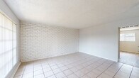 Located at 910 Fair Oaks Rd in Houston, TX, this single-story, 2-bedroom, 1-bathroom home offers a straightforward and functional layout. The living room serves as the welcoming centerpiece, featuring large tile flooring, a striking white-painted exposed brick accent wall, and a wide window that allows natural light to fill the space. The clean, neutral color palette throughout creates a bright and open atmosphere.

The kitchen is efficiently designed with white cabinetry, light countertops, a double-basin stainless steel sink, and wood-style flooring, providing ample storage and workspace in a compact arrangement. A dishwasher is also included.

Both bedrooms feature light wood-style laminate flooring and ceiling fans with integrated lighting. The generously sized primary bedroom includes a double-door closet, offering practical storage. Each bedroom benefits from windows that invite natural light and provide outdoor views.

The bathroom is clean and straightforward, featuring a full tub and shower combination with white tile surround and chrome fixtures. Wood-style flooring continues into this space, maintaining consistency throughout the home.

Textured ceilings are present throughout, and the overall interior is finished in a neutral white palette that enhances the sense of brightness. Two closets provide additional storage across the home.