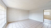 Located at 910 Fair Oaks Rd in Houston, TX, this single-story, 2-bedroom, 1-bathroom home offers a straightforward and functional layout. The living room serves as the welcoming centerpiece, featuring large tile flooring, a striking white-painted exposed brick accent wall, and a wide window that allows natural light to fill the space. The clean, neutral color palette throughout creates a bright and open atmosphere.

The kitchen is efficiently designed with white cabinetry, light countertops, a double-basin stainless steel sink, and wood-style flooring, providing ample storage and workspace in a compact arrangement. A dishwasher is also included.

Both bedrooms feature light wood-style laminate flooring and ceiling fans with integrated lighting. The generously sized primary bedroom includes a double-door closet, offering practical storage. Each bedroom benefits from windows that invite natural light and provide outdoor views.

The bathroom is clean and straightforward, featuring a full tub and shower combination with white tile surround and chrome fixtures. Wood-style flooring continues into this space, maintaining consistency throughout the home.

Textured ceilings are present throughout, and the overall interior is finished in a neutral white palette that enhances the sense of brightness. Two closets provide additional storage across the home.