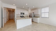 Located in Bradenton, Florida, this two-story home offers a clean, contemporary design with a bright and neutral color palette throughout. The kitchen is a standout feature, showcasing white shaker cabinetry, granite countertops, a central island with a sink, and stainless steel appliances including a range, microwave, and refrigerator. Recessed lighting and light tile flooring give the kitchen an open, airy feel. A convenient half bath on the main level features a pedestal sink and tile flooring, while a full bathroom includes a soaking tub and shower combination with full-height stone tile surround. Bedrooms are finished with plush carpeting and bright white walls, with select rooms offering multiple windows that invite natural light and outdoor views. A wide hallway with tile flooring connects the main-level rooms, with a staircase featuring a warm wood handrail and white balusters leading to the upper floor. The dedicated laundry area houses a full-size washer and dryer. The attached garage provides additional storage and utility space, complete with an automatic door opener and an electrical panel. This well-appointed home combines functional design with modern finishes throughout.
