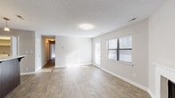 Located at 6317 Shanda Dr in Raleigh, NC, this single-floor, 3-bedroom, 2-bathroom home offers a functional and comfortable layout. The open living area features light-toned hardwood-style flooring, neutral walls, a textured ceiling, and windows fitted with blinds that allow natural light to fill the space. A door leads to an outdoor area, adding a sense of openness to the main living space.

The kitchen is well-appointed with rich dark wood cabinetry, light countertops, and a full suite of stainless steel appliances including a refrigerator, electric range, and dishwasher. Pendant lighting above the counter and hardwood-style flooring complete the kitchen's practical yet stylish character.

The three bedrooms feature plush carpeting and neutral gray walls. Each room receives natural light through large windows with outdoor views. The primary bedroom includes access to a dedicated closet, while additional bedrooms also feature closet storage. One bedroom includes built-in shelving alongside a window, providing convenient organizational space.

Both bathrooms are equipped with a tub-shower combination featuring a clean white surround with integrated shelving and brushed nickel fixtures. Multiple hallways connect the rooms efficiently throughout the home, which also includes three dedicated closets for ample storage.