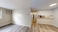 Located at 8213 College Trail in Inver Grove Heights, MN, this single-floor unit offers five bedrooms and two bathrooms within a efficiently laid-out floor plan. Light-toned luxury vinyl plank flooring runs throughout the main living areas and bedrooms, creating a cohesive and easy-to-maintain aesthetic.

The open living area connects to a galley-style kitchen outfitted with rich cherry wood cabinetry, granite-look countertops, a stainless steel sink, and stainless steel appliances including a refrigerator, range, and dishwasher. A pass-through counter opens the kitchen toward the living space, enhancing the flow between rooms.

A long central hallway connects the five bedrooms, each featuring neutral wall tones and individual closets with wire shelving for ample storage. The spacious primary bedroom includes a window with outdoor views and a wall-mounted air conditioning unit alongside baseboard heating. Additional bedrooms are generously sized with dedicated closets.

The two bathrooms offer tile flooring, granite-look vanity countertops, and tub-shower combinations with white tile surrounds. One bathroom conveniently houses an in-unit washer. Clean white trim, textured ceilings, and a neutral color palette throughout lend the space a fresh, move-in-ready feel.