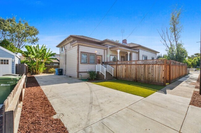 A wider view of the front of the property with a front lawn and long private driveway - 1425 Madison St