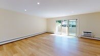 Located at 38 Douglas Terr in North Providence, Rhode Island, this three-floor residence offers a thoughtfully updated interior with consistent, modern finishes across all levels. Light hardwood flooring flows throughout the living areas and bedrooms, creating a bright and cohesive aesthetic complemented by recessed lighting and warm, neutral wall tones.

The main living area is generously proportioned, featuring sliding glass doors that open to a private deck with outdoor views, allowing natural light to fill the space. Baseboard heating runs throughout the home, ensuring comfort across all seasons.

The kitchen is a standout feature, showcasing white shaker-style cabinetry, dark granite countertops, a classic subway tile backsplash, and a full suite of stainless steel appliances, including a gas range, microwave, and refrigerator. A window above the sink brings in additional natural light.

Bedrooms are well-sized with ample closet space, including sliding and walk-in closets, and wall-unit air conditioning. The bathrooms are cleanly finished with grey tile flooring, white vanities, and dark countertops. The full bath features a glass-enclosed walk-in shower with subway tile surround. The lower level includes an unfinished basement, ideal for additional storage.