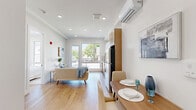 Located at 40 Lembeck Ave in Jersey City, NJ, this thoughtfully designed 2-bedroom, 1-bathroom unit offers a modern and efficient living space. The open-concept layout seamlessly connects the kitchen and living area, creating a bright and welcoming atmosphere enhanced by recessed lighting and light oak hardwood flooring throughout.

The contemporary kitchen is well-appointed with two-tone cabinetry — combining high-gloss white upper cabinets with natural wood lower cabinets — complemented by a white subway tile backsplash, stainless steel appliances including a gas range, built-in microwave, refrigerator, and dishwasher. A large window in the living area fills the space with natural light and provides views of the surrounding neighborhood.

Both bedrooms are finished with the same warm hardwood floors and crisp white walls. The primary bedroom features a large picture window that invites abundant natural light and offers outdoor views. A wall-mounted mini-split system ensures year-round comfort. The second bedroom is equally bright with its own window.

The bathroom is clean and modern, featuring neutral rectangular tile extending floor to ceiling in the shower/tub surround, paired with light tile flooring. The unit's overall aesthetic is cohesive — minimal, fresh, and move-in ready.