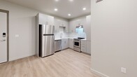 Located at 268 W 400 S in Salt Lake City, Utah, this single-floor unit presents a clean, modern aesthetic defined by light wood-style flooring, crisp white walls, and recessed lighting throughout. The open kitchen is a standout feature, outfitted with sleek gray cabinetry, white subway tile backsplash, light-toned countertops, and a full suite of stainless steel appliances, including a gas range, dishwasher, and full-size refrigerator. The layout flows efficiently, offering ample cabinet storage and a functional workspace for everyday use. The bedroom is a well-proportioned, light-filled room featuring a wide horizontal window fitted with blinds, allowing natural light to enter while maintaining privacy. An adjacent walk-in closet provides dedicated storage with a hanging rod and shelving. The bathroom is finished in the same neutral palette, featuring a sliding-door glass walk-in shower, a modern vanity with light countertops and gray cabinetry, and wood-style flooring that ties cohesively to the rest of the unit. The overall ambiance is clean, contemporary, and move-in ready.