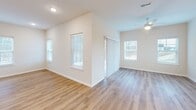 Located at 1352 Town Square Dr in Kent, Ohio, this well-appointed single-floor home offers 2 bedrooms and 2 bathrooms within a thoughtfully designed layout. The heart of the home is an expansive open-concept living, dining, and kitchen area bathed in natural light from large windows. The kitchen showcases white shaker cabinetry, a classic subway tile backsplash, a central island with a sink, pendant lighting, and a full suite of stainless steel appliances including a gas range, microwave, and French door refrigerator. Warm-toned luxury vinyl plank flooring flows throughout the main living areas, creating a cohesive and clean aesthetic. The generously sized primary bedroom features soft carpeting, multiple windows with natural light, and access to a private en-suite bathroom equipped with a dual-sink vanity and a glass-enclosed shower. A spacious walk-in closet with extensive wire shelving provides ample storage. The second bedroom is equally comfortable with plush carpet and a bright window. The second full bathroom includes a tub-shower combo and a white vanity. Additional highlights include multiple closets, a dedicated laundry room, pantry, utility room, and a hallway connecting the layout efficiently.
