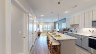Located at 2237 Riley Fuzzel Rd in Spring, TX, this well-appointed one-bedroom, one-bathroom residence offers a thoughtfully designed open-concept layout across a single floor. The kitchen is a standout feature, showcasing light wood cabinetry reaching to the ceiling, sleek gray lower cabinets, crisp white quartz countertops, and a full suite of stainless steel appliances. A central island with seating provides additional workspace and casual dining opportunities, while pendant lighting adds a contemporary touch. Wide-plank wood-style flooring flows seamlessly throughout the main living areas, enhancing the sense of continuity and warmth. The living room features a soothing blue accent wall, large windows that invite abundant natural light, and access to an outdoor balcony with exterior views. The primary bedroom continues the accent wall palette, complemented by a ceiling fan, a generous window with outdoor views, and easy access to a dedicated closet. The bathroom is finished with large-format marble-look tile flooring, a gray vanity with ample drawer storage, and built-in open shelving for organized storage. Clean white walls and matte black fixtures throughout lend the space a modern, cohesive aesthetic. This residence offers a comfortable and stylish living experience in a desirable Spring, Texas location.