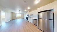 Located at 3295 Burlington Ave N in Saint Petersburg, FL, this well-appointed one-bedroom, one-bathroom unit offers a thoughtfully designed single-floor layout with a clean, contemporary aesthetic throughout. Light wood-tone flooring flows seamlessly across every room, lending warmth and visual continuity to the space.

The open-concept kitchen and living area serves as the heart of the unit. The kitchen is outfitted with crisp white flat-panel cabinetry extending to the ceiling for ample storage, a subway tile backsplash, white quartz-style countertops, and a full suite of stainless steel appliances including a range, over-the-range microwave, dishwasher, and full-size refrigerator. Flush-mount ceiling lights provide bright, even illumination.

The living area is spacious and open, with a ceiling fan overhead and direct sightlines to the entryway hallway, which includes a utility panel and closet storage.

The bedroom is generously sized, featuring a ceiling fan, a large window overlooking a balcony with lush outdoor greenery, and a built-in double-door closet. Natural light pours in, creating a bright and comfortable retreat.

The bathroom is finished with a white vanity, white countertop, large mirror with contemporary lighting, and consistent wood-tone flooring, maintaining the unit's modern and cohesive design.