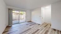Located in Roseville, CA, this well-appointed one-bedroom, two-bathroom residence offers a clean, functional layout across a single floor. Light wood-style flooring flows consistently throughout the space, contributing to a bright and cohesive aesthetic.

The living area is an inviting, open space featuring sliding glass doors that lead directly to a private outdoor patio, filling the room with natural light and providing easy access to the outdoors. The front entry door is conveniently positioned alongside the patio access.

The galley-style kitchen is efficiently designed with white cabinetry lining both sides, granite-style countertops, a stainless steel sink, and white appliances including a range with coil burners and a refrigerator. A window at the end of the kitchen allows natural light to brighten the workspace.

The bedroom is a comfortably sized room with a large window fitted with vertical blinds, offering views of outdoor greenery. A sliding closet provides ample built-in storage. The room connects conveniently to one of the two bathrooms, which features a granite-style vanity countertop and sliding mirrored closet doors. The second bathroom includes a full tub-shower combination with clean white surrounds. Textured ceilings are present throughout, adding a classic finishing detail to this tidy and functional residence.